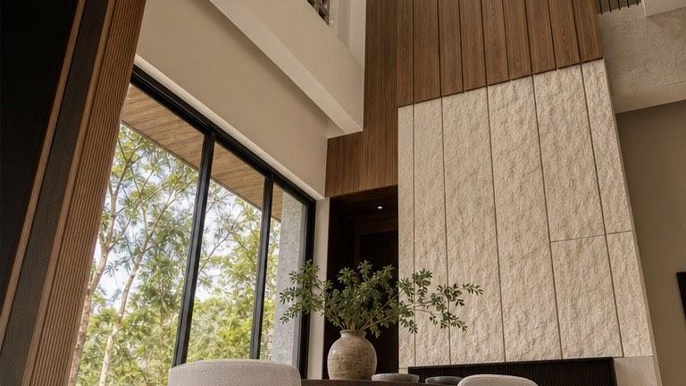 Double-height atrium at the Bangi house clad in timber and split-face stone