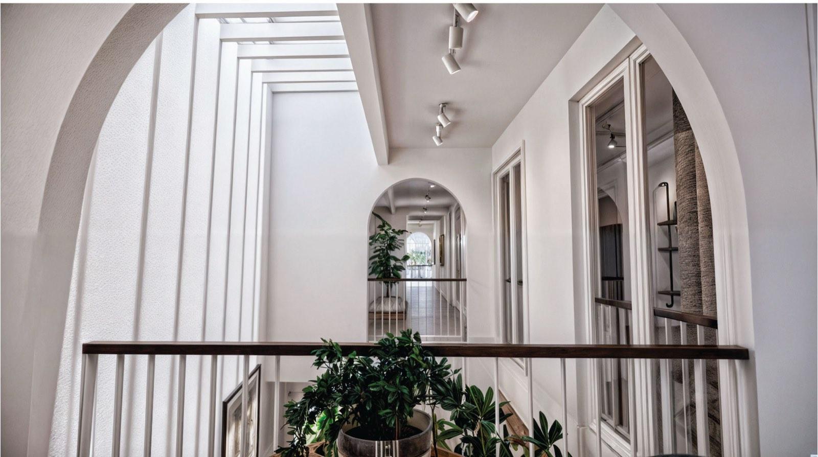 Arched gallery corridor of the Kuala Lumpur terrace house overlooking the planted atrium void