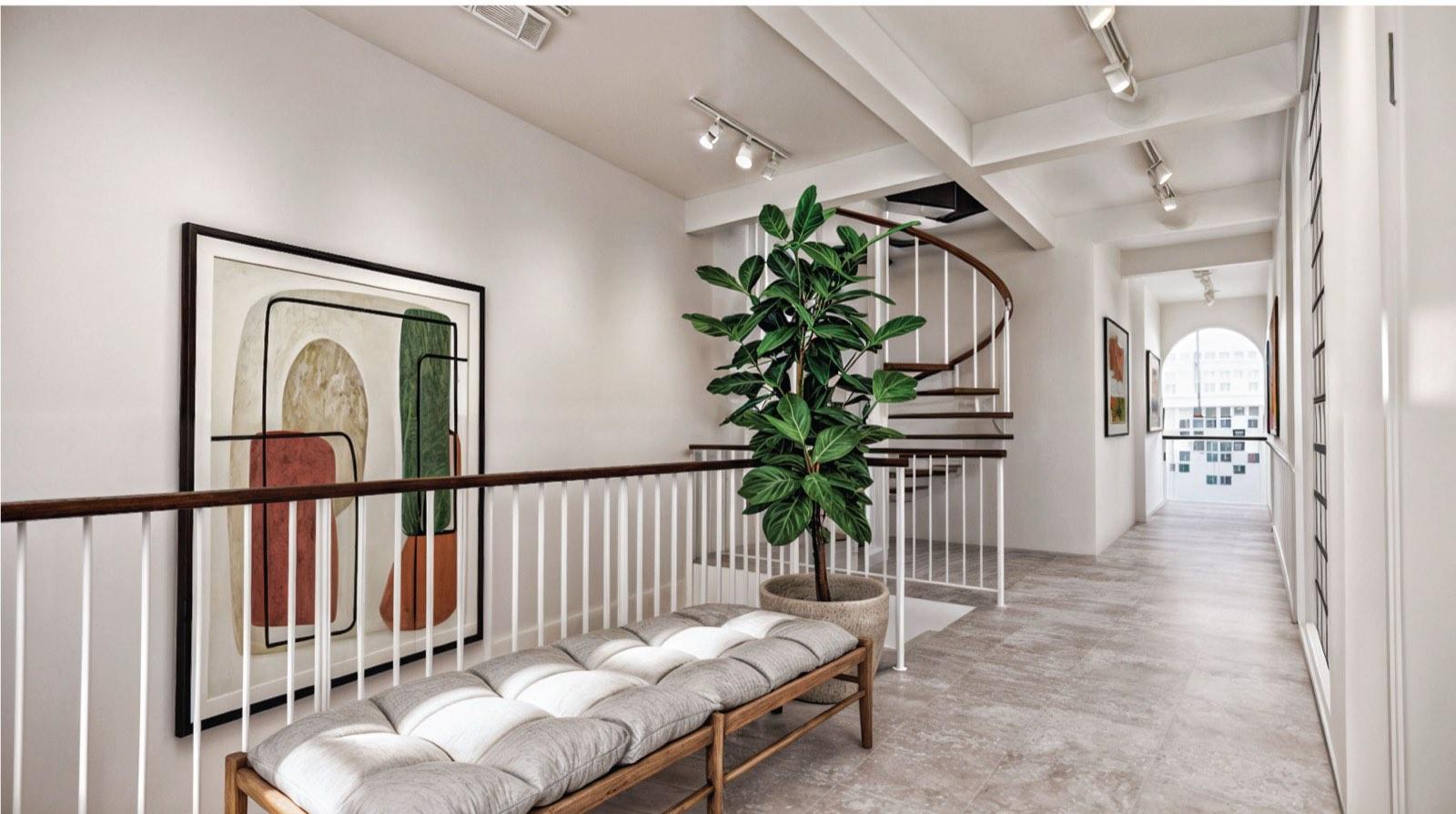Upstairs landing of the Kuala Lumpur terrace house with a cushioned bench, spiral stair and arched opening