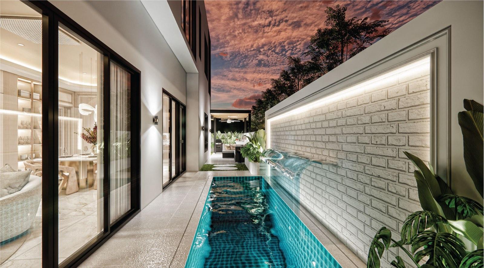 Turquoise-tiled lap pool at dusk along the side of the Monarc, Gamuda Gardens house, against a lit white brick wall