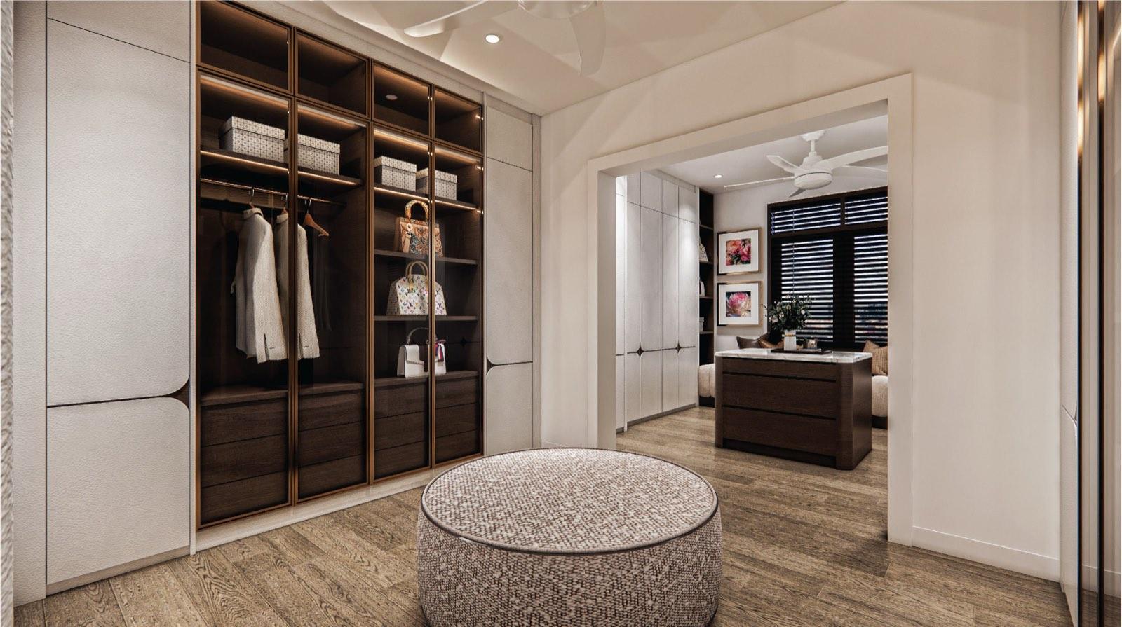 Walk-in wardrobe at the Putrajaya villa with bronze-framed glass display cabinets and a round ottoman