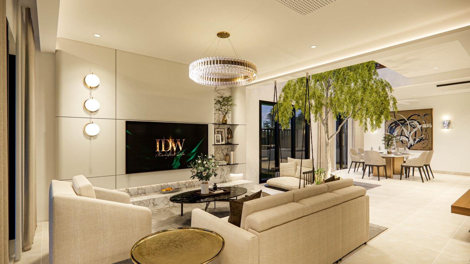 Living room of the Sime Darby show unit under a crystal ring chandelier, with the courtyard tree and swing seat beside the sofas